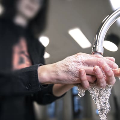 Ihminen pesee käsiään.