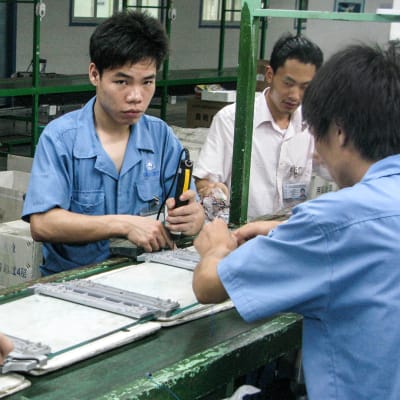 Miehiä työskentelemässä kiinalaisessa tehtaassa.