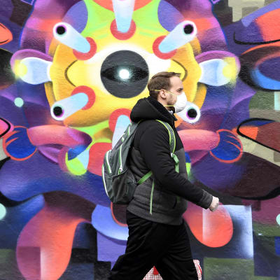Mies kävelee Dublinissa koronavirusta esittävän muraalin ohi.