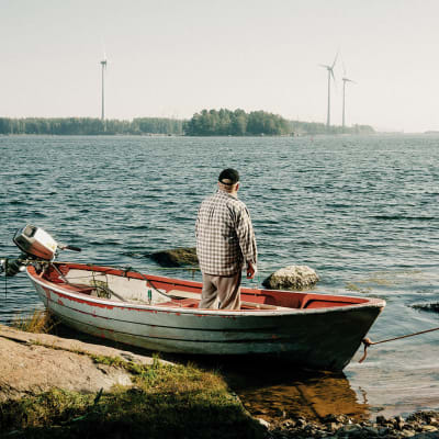 Jarmo Mustonen kattoo soutuveneessään merelle.