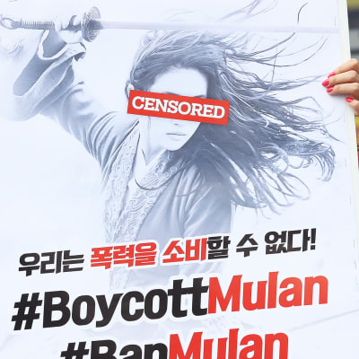 Eteläkorealaisen aktivistin juliste kehottaa boikotoimaan Mulan-elokuvaa Soulissa.