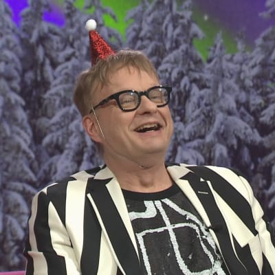 Muusikko Iiro Rantala Puoli seitsemän -ohjelman studiossa iloisena jouluhattu päässään.