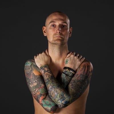 Ted Johansson med bar överkropp och tatueringar.