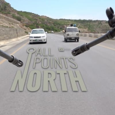 Video still of two rifles pointed from the back of a vehicle driving along a road in Afghanistan featuring the All Points North Podcast logo.