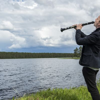 Lauri Sallinen soittaa klarinettia järven rannalla