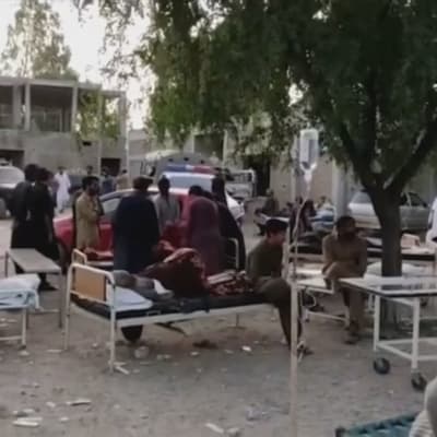 Människor väntade utanför sjukhuset i Harnai på torsdag morgon. Harnai ligger nära skalvets epicentrum i den pakistanska provinsen Baluchistan. 