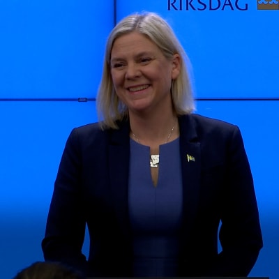 Magdalena Andersson ler mot kameran udner en presskonferens.