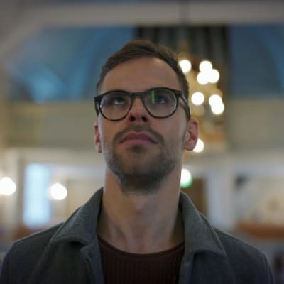 Alaric Mård betraktar en altartavla som man inte kan se i bilden 