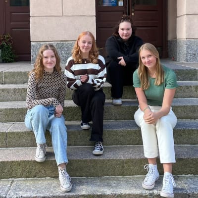 Bianca Vuorenmaa Närvä, Victoria Kärkinen, Saara Manni och Iréne Heikius sittande på en trappa. 