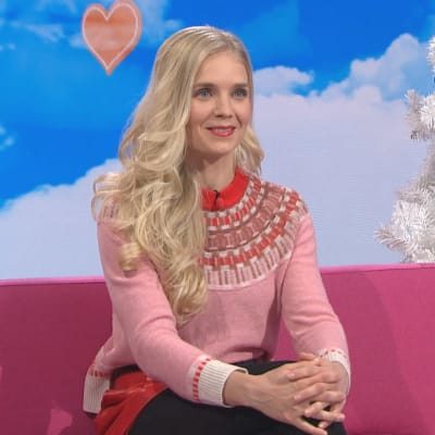 Vuorikiipeilijä Lotta Hintsa istuu Puoli seitsemän -ohjelman pinkillä sohvalla. 