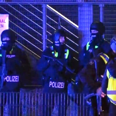 Poliser spärrar av en byggnad efter masskjutning.
