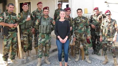 Mariette Hägglund står tillsammans med en grupp Peshmergasoldater vid en frontlinje mot IS (2017). 