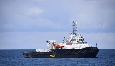 Ryska flottans fartyg SB-123 har svart skrov och vit överdel, med master stickande upp från taket.
