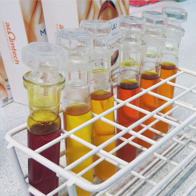 Kellertäviä ja punertavia tyrniöljyjä koeputkissa Aromtechin laboratoriossa. 