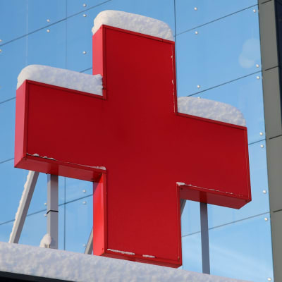 Stort rött, snötäckt kors vid vid en ingång till Vasa centralsjukhus. 