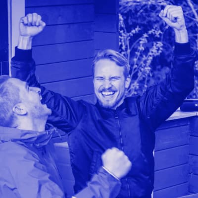 Kaksi miestä riemuitsee kesämökillä radio taustalla.