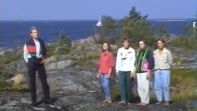 Fem personer sjunger på en klippa.