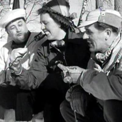 Ihmisiä talvimaisemassa 1950-luvun mainosfilmissä