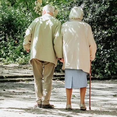 Ett äldre par som promenerar på en sandväg