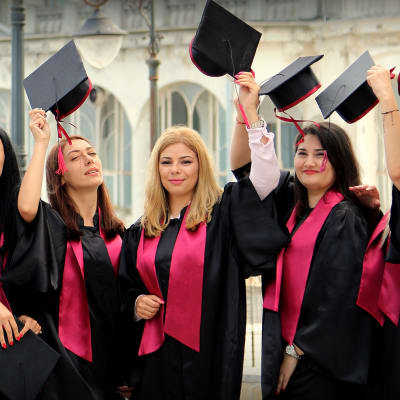Irina Pican (keskellä) unelmoi hammaslääkärin urasta Yhdysvalloissa. Naiset juhlivat yliopiston päättäjäisiä Constantan satamakaupungissa Romaniassa.