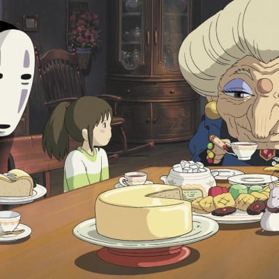 Animaatiokuvassa naamaripäinen hahmo, pieni tyttö ja vanha mummo istuvat pöydän äärellä.