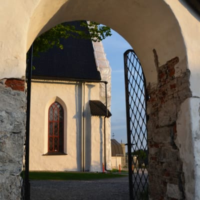Genom kyrkporten syns en del av Borgå domkyrka i kvällssolen.