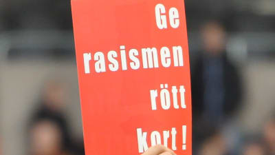 Spelare med Ge rasismen rött kort-skylt.