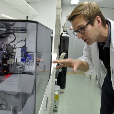 Niklas Sandler bredvid en 3D-printer.