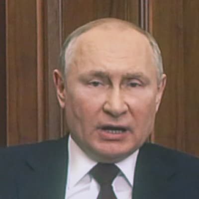 President Vladimir Putin håller tv-tal. Svarta siluetter av människor som tittar syns i förgrunden.