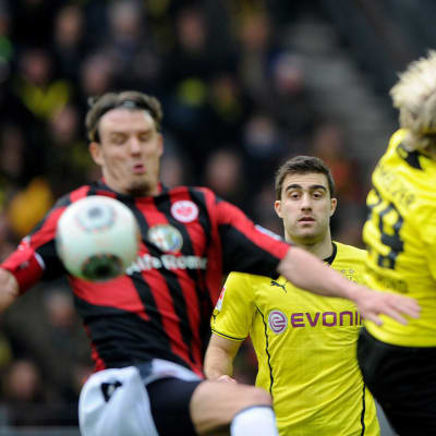 Dortmundin Sokratis seuraa taustalla, kun Frankfurtin Alexander Meier ja Dortmundin Marcel Schmelzer taistelevat pallosta.