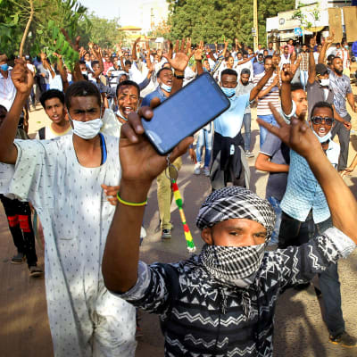 Sudanilaiset mielenosoittajat marssivat kadulla.