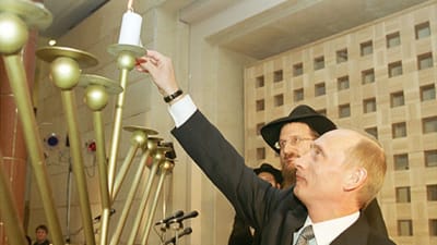 Vladimir Putin tänder ljus i en hannukah-menorah tillsammans med rabbinen Berel Lazar i december 2000.