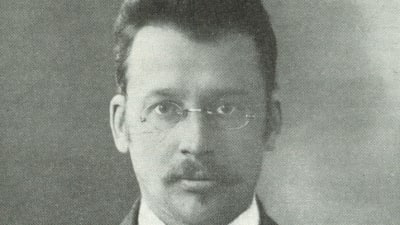 Karl Harald Wiik, SDP:s ordförande och riksdagsman, grundare av DFFF och dess ordförande kort. Svart vitt foto av en mörkhårig, glasögonprydd, prydlig man.