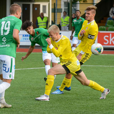 EIF:s Darren Smith skjuter bollen förbi några Kajanaspelare.