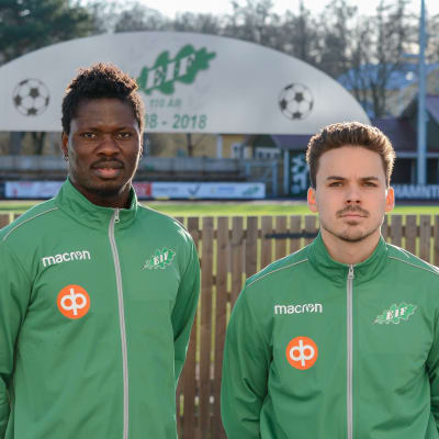 Två fotbollsspelare i gröna kläder.