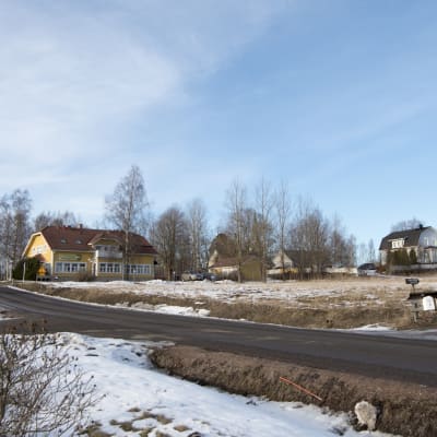 Hus på andrasidan av en åker.