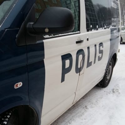 En polisbil har stannat på en snöig gata.