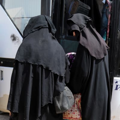 Kvinnor stiger ombord på en buss i al-Hol-lägret i Syrien.