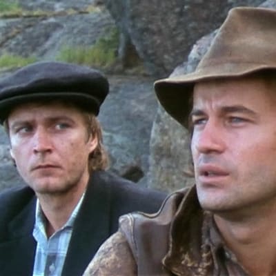 Renkonen ja Joel istuvat kallioilla Musta hurmio -elokuvassa.