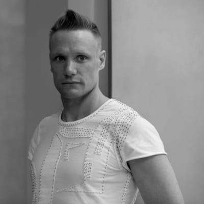 Timo Rissanen, professor i mode och hållbarhet vid Parsons New School of Design i New York. Ung kortklippt man i vit t-skjorta.