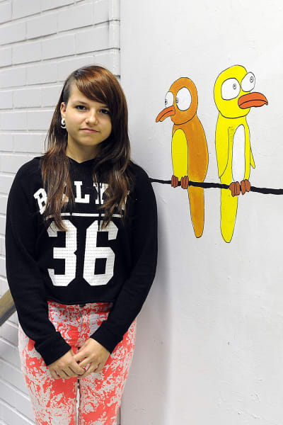 Anastasia Alexandrova, elev i Närpes högstadieskola, står i korridoren framför målning av fåglar