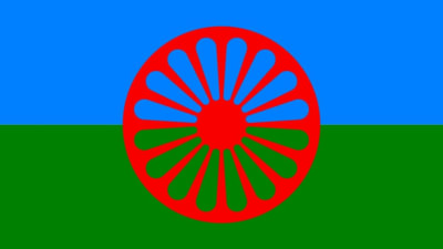 Romanilipussa on punainen rattaanpyörä sinisellä ja vihreällä pohjalla.