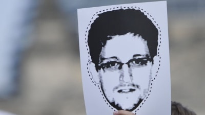 hand håller uppe Edward Snowden-bild som mask att klippa ut.