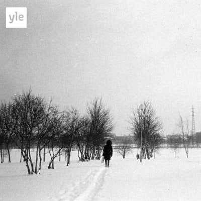 En man går på en stig i snön