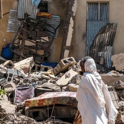 En kvinna framför ett skadat hus i Wukro norr om Mekele i Etiopien