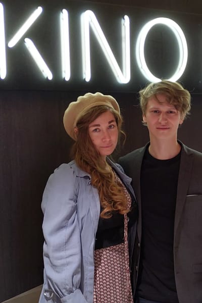 Cina Monn och Erik Enge poserar framför en biografskylt i neon med texten Kino Regina.