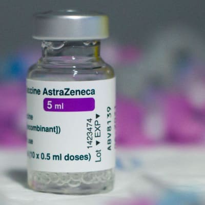 Dos av Astra Zenecas coronavaccin i bakgrunden och sprutor i förgrunden.