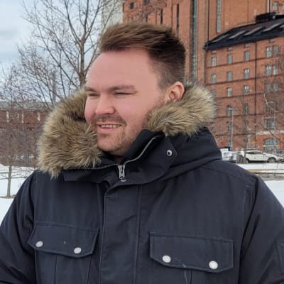 Man i vinterjacka står på en brygga.