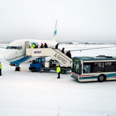 Ensimmäinen Rovaniemelle laskeutunut charterkone tyuli Varsovasta. Matkustajat siirtyvät koneesta linja-autoon.