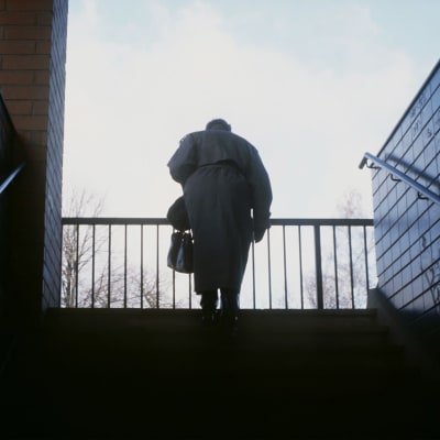 Vanha nainen kävelee portaita ylös helmikuussa 1990.